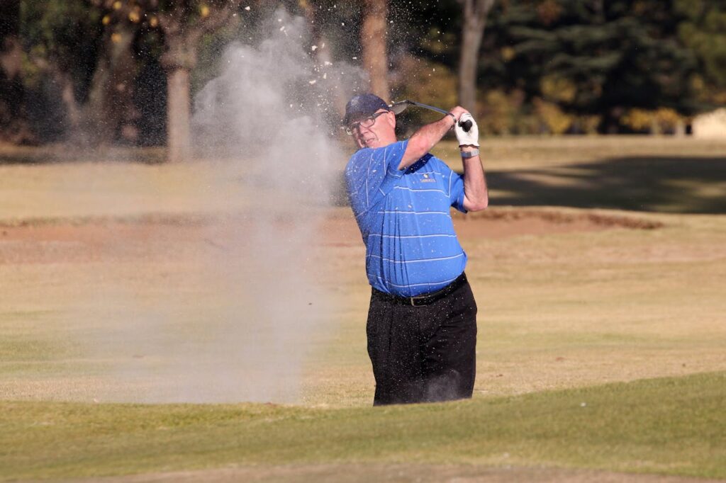 Golfer learning how can seniors hit the golf ball further from the bunker